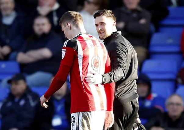 Sheffield Unityed's Caolan Lavery goes off injured against Oldham