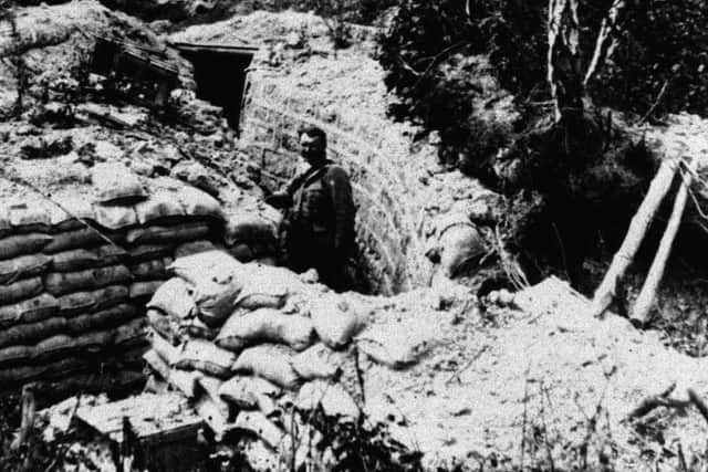 A soldier from the American Expeditionary Force inspecting a trench abandoned by the German Army on the Western Front in France in 1918. (PA).
