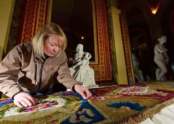 Conservator Caroline Rawson examining historic clothes moth damage to a carpet at Brodsworth Hall in Yorkshire, as experts have warned that the insects are an increasing risk to the nation's heritage.