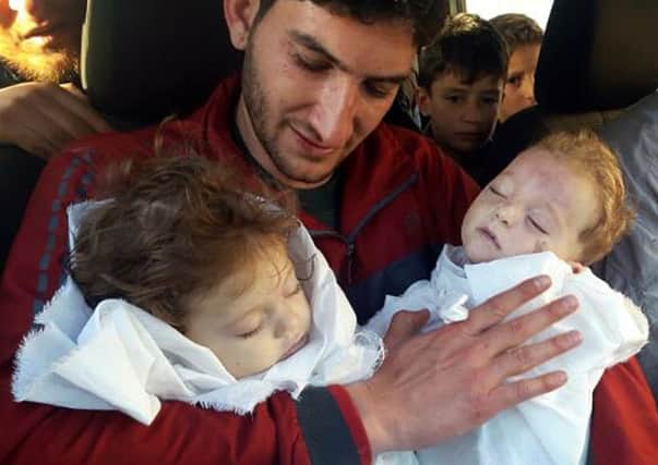 In this picture taken on Tuesday April 4, 2017, Abdul-Hamid Alyousef, 29, holds his twin babies who were killed during a suspected chemical weapons attack, in Khan Sheikhoun in the northern province of Idlib, Syria. Alyousef also lost his wife, two brothers, nephews and many other family members in the attack that claimed scores of his relatives. The death toll from a suspected chemical attack on a northern Syrian town rose to 72 on Wednesday as activists and rescue workers found more terrified survivors hiding in shelters near the site of the harrowing assault, one of the deadliest in Syria's civil war. (Alaa Alyousef via AP)