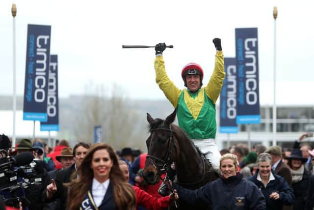 Jockey Robbie Power celebrates after his winning ride on Sizing John in the Timico Cheltenham Gold Cup Chase.