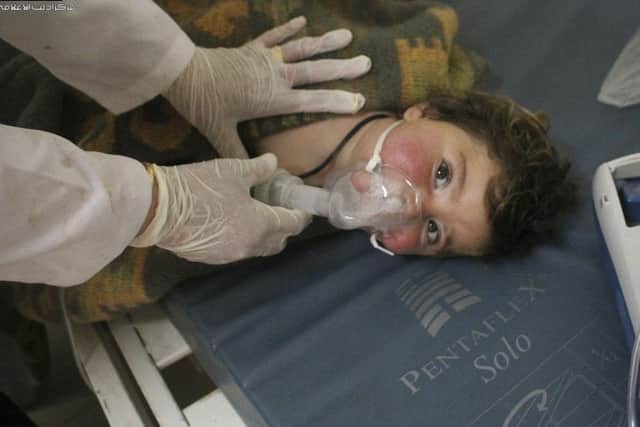 This photo was provided by the Syrian anti-government activist group Edlib Media Center, which has been authenticated based on its contents and other AP reporting, shows a Syrian doctor treating a child following a suspected chemical attack, at a makeshift hospital, in the town of Khan Sheikhoun, Syria.