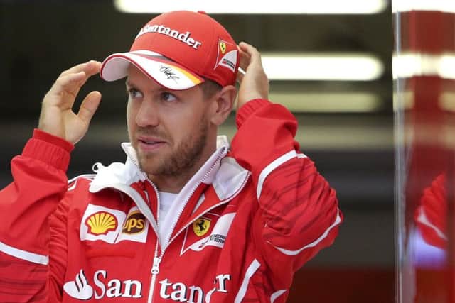 Ferrari driver Sebastian Vettel of Germany walks out of his team's garage after the second practice session for the Chinese Formula One Grand Prix. (AP Photo/Toru Takahashi)