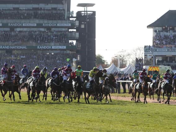 The runners prepare for the start at the Grand National