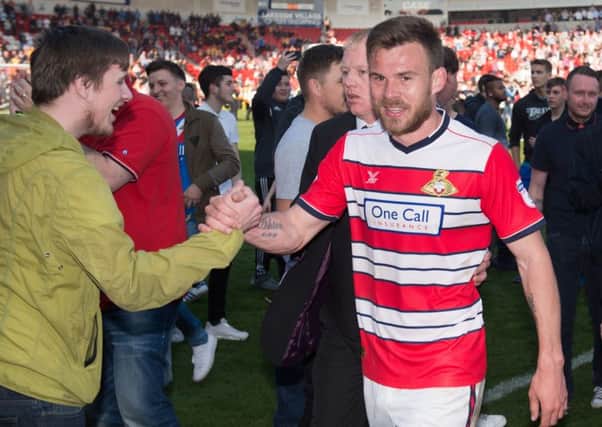 Early celebrations: Doncaster Rovers players celebrate clinching promotion from League Two with five games to spare after a 1-0 home victory over Mansfield Town at the Keepmoat Stadium. Left, Tommy Rowe heads home the goal that clinched promotion. Right, captain Andy Butler is congratulated by the fans. (Pictures: PA)