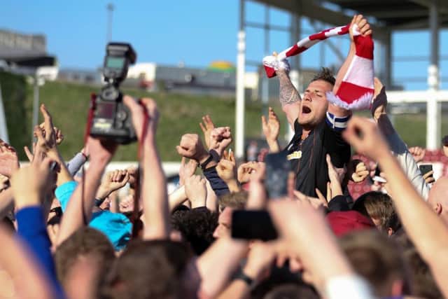 Celebration time: Sheffield United top scorer and captain Billy Sharp is hoisted by Blades fans after promotion to the Championship is confirmed with victory at Northampton. (Picture: Simon Bellis/Sportimage)