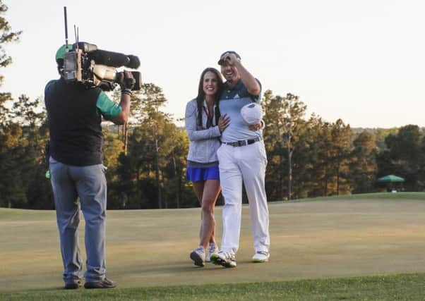 Sergio Garcia, of Spain, walks off the 18th hole with his sportily dressed fiancee Angela Akins after making his birdie putt to win the Masters golf tournament on Sunday, April 9, 2017, in Augusta, Ga. (AP Photo/Chris Carlson)