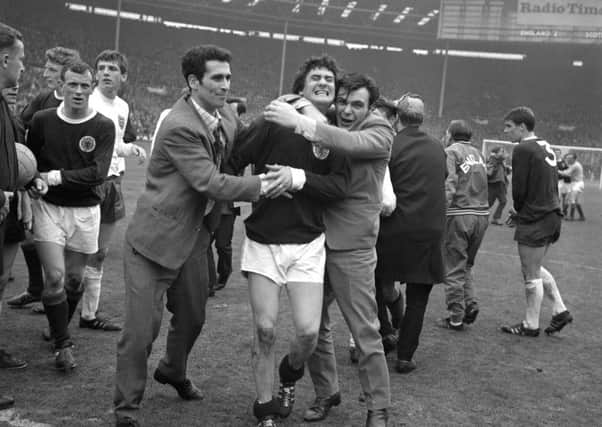 WINNER: Scotland's Jim Baxter is hugged by fans who invaded the pitch at Wembley following the 3-2 victory over England in April 1967. Picture: PA.