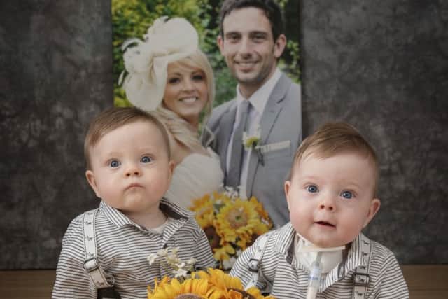 Austin and Rory Hardy  in front of a picture of Kelly and Ashley at their wedding in 2012. Picture by Mikael Lamber Photography
