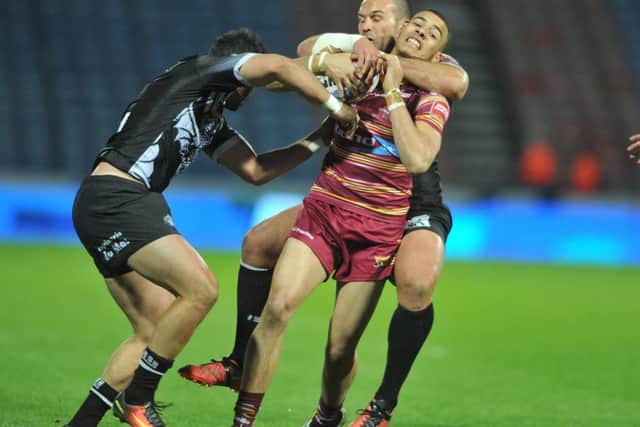 Huddersfield Giants' Darnell McIntosh caught in a high tackle by Dragons' Samuela Moa.  (Picture: Tony Johnson)