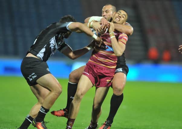 Huddersfield Giants' Darnell McIntosh caught in a high tackle by Dragons' Samuela Moa.  (Picture: Tony Johnson)