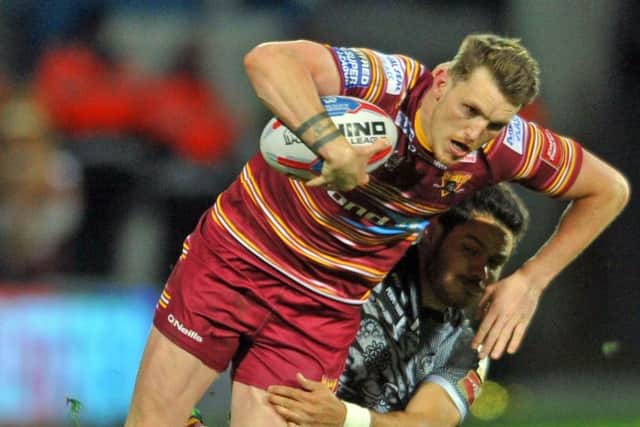 Held back: Lee Gaskell is tackled by Catalans Dragons Brayden Williame as Huddersfield Giants endured a torrid night on home soil, losing for the seventh game in succession. (Picture: Tony Johnson)