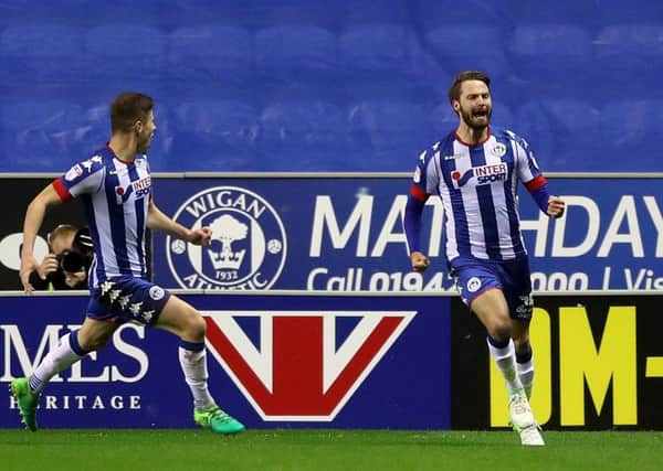 Wigan Athletic's Nick Powell (right) celebrates scoring one of his three goals in 11 minutes that sank Barnsley on Thursday night. Picture: Martin Rickett/PA