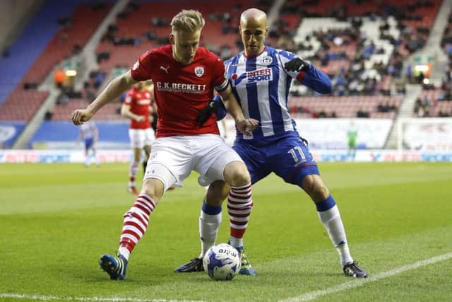 Wigan Athletic's Gabriel Obertan battles for the ball with Barnsley's Marc Roberts. Picture: Martin Rickett/PA.