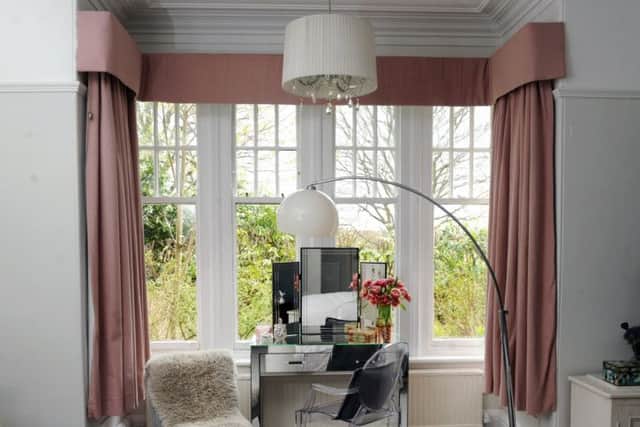 The beautiful bay window in Louise's bedroom has been dressed with dusky pink drapes