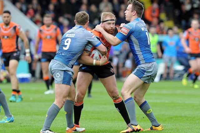 STOP RIGHT THERE: Castleford Tigers' Oliver Holmes finds his path forward blocked by Wakefield Trinity. Picture: Scott Merrylees