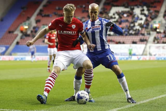 Wigan Athletic's Gabriel Obertan battles for the ball with Barnsley's Marc Roberts, left. Picture: Martin Rickett/PA