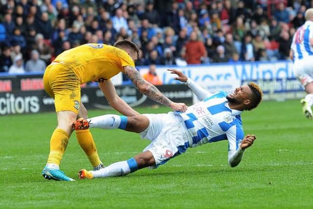 OVER YOU GO: 
Huddersfield's Elias Kachunga clashes with Preston's Jordan Hugill, which led to the the crucial, late penalty.
 Picture: Jonathan Gawthorpe
