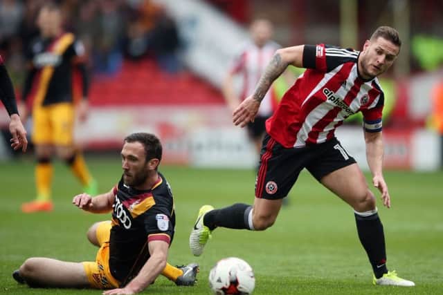 Sheffield United's Billy Sharp (right) and Bradford City's Rory McArdle battle for the ball at Bramall Lane on Easter Monday. Picture: Nick Potts/PA.