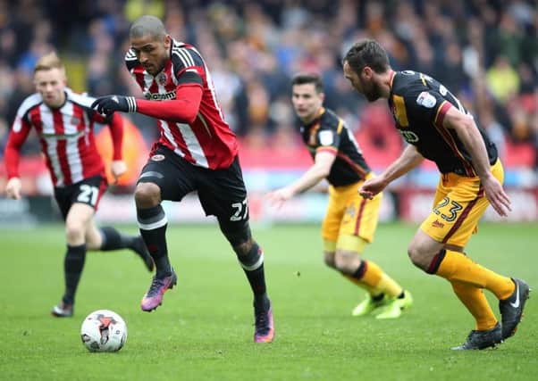 Sheffield United's Leon Clarke, left, and Bradford City's Rory McArdle battle for the ball at Bramall Lane on Monday. Picture: Nick Potts/PA