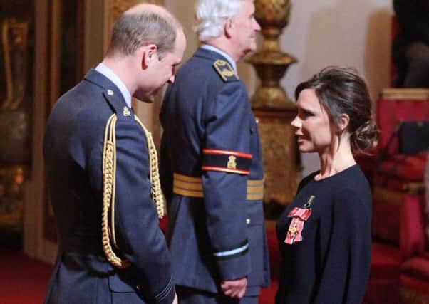 Victoria Beckham receives her OBE from the Duke of Cambridge.
