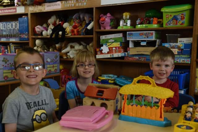 James and Jessica Thompson, six, and William Adams are visitors at the library