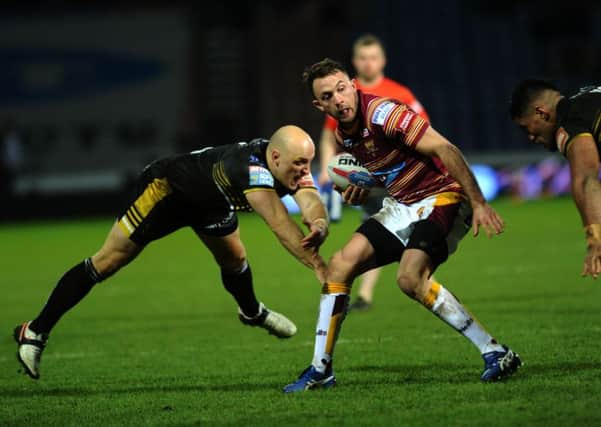 Huddersfield's Ryan Brierley escapes a tackle from Salford's Michael Dobson.
(Picture: Jonathan Gawthorpe)