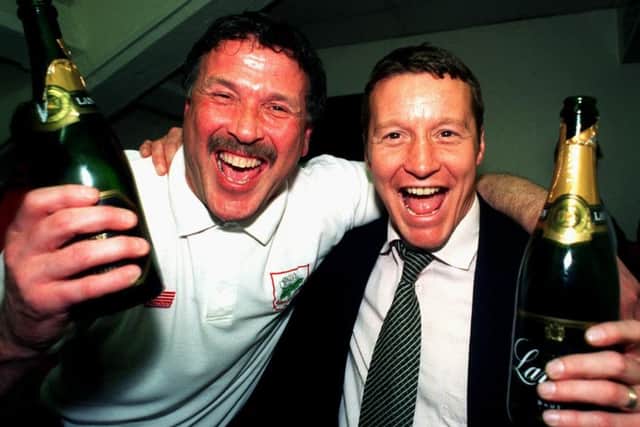 GREAT DAYS: Barnsley manager Danny Wilson and his assistant  Eric Wins tanley celebrate promotion to the Premership with champagne.