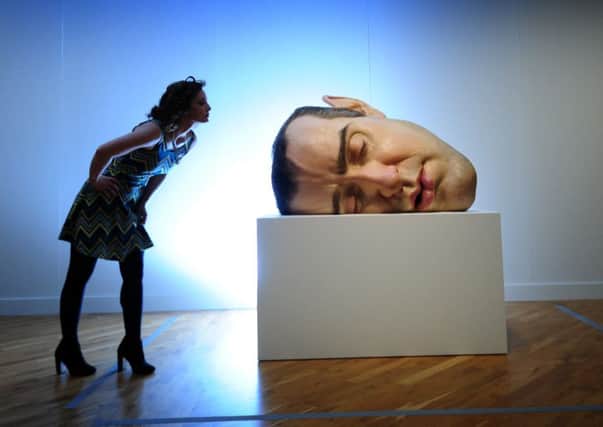 A woman looks at  Sculpture Mask 11 by Ron Mueck at the Ferens Art Gallery in Hull.