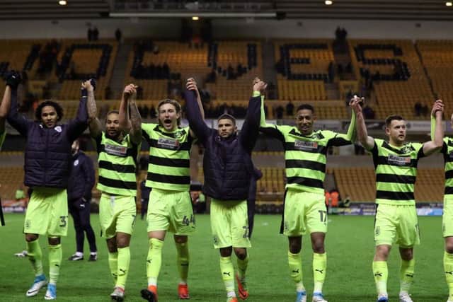 The Huddersfield squad celebrate reaching the Championship play-offs with the travelling support at Molineux