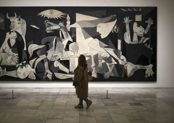 A woman looks at the "Guernica" painting by Pablo Picasso. Picasso's path to Guernica exhibition is on at the Reina Sofia museum in Madrid. (AP)