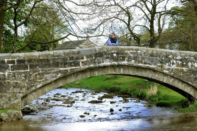 Chris Gregson at the centre of the pack horse bridge in the centre of the village.