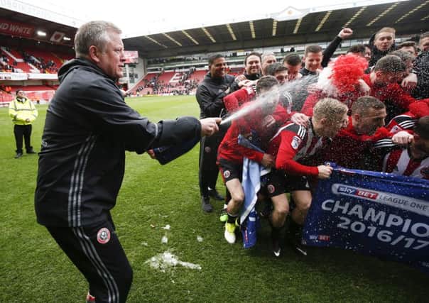 Blades boss Chris Wilder sprays champagne over his players.