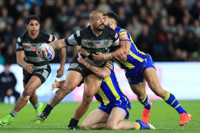 Hull FC's Sika Manu (centre) is tackled by Warrington Wolves' Rhys Evans and Benjamin Jullien.