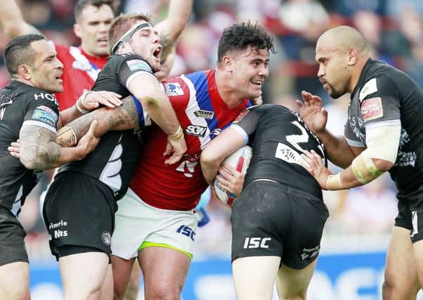 Wakefield's David Fifita is tackled by Catalans defenders.