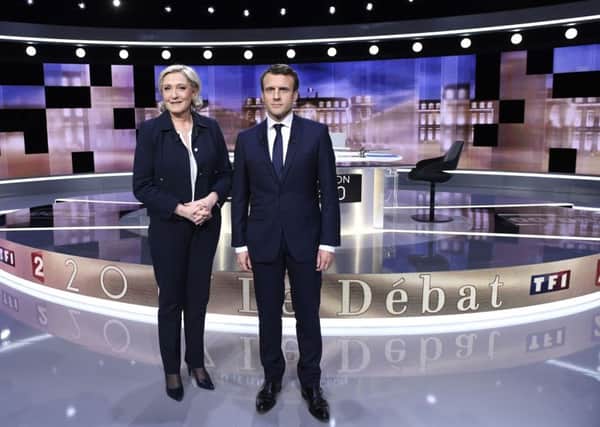 French presidential election candidate for the far-right Front National party, Marine Le Pen, left, and French presidential election candidate for the En Marche ! movement, Emmanuel Macron, pose prior to the start of a live broadcast face-to-face televised debate in La Plaine-Saint-Denis, north of Paris, France, Wednesday, May 3, 2017 as part of the second round election campaign. Pro-European progressive Emmanuel Macron and far-right Marine Le Pen are facing off in their only direct debate before Sunday's presidential runoff election.