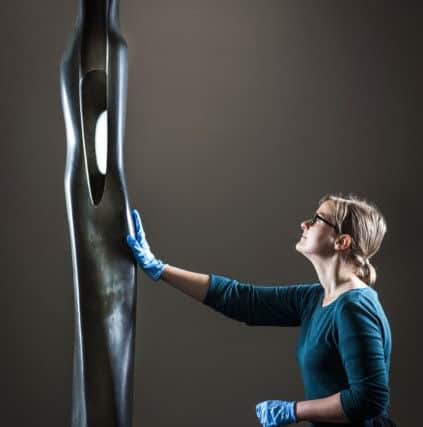 Eleanor Clayton, curator at The Hepworth Wakefield inspects a newly conserved Barbara Hepworth sculpture. Danny Lawson/PA Wire.