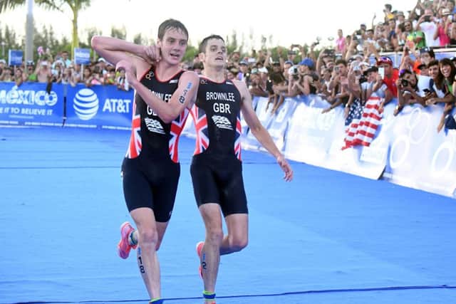 Britain's Alistair Brownlee, left, helps his brother Jonny to get to the finish line during the Triathlon World Series event in Cozumel, Mexico, Sunday Sept. 18, 2016.  Exhausted Jonny  Brownlee began to weave over the road in hot and humid conditions, when third-placed Alistair, caught his brother, propping him up for the final couple of hundred metres before pushing him over the line in second place. (Delly Carr/AP)