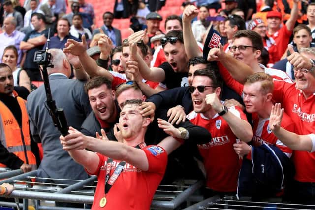 Barnsley's Sam Winnall celebrates with a GoPro camera and fans after winning the League One Play-Off Final at Wembley. Picture: Nick Potts/PA