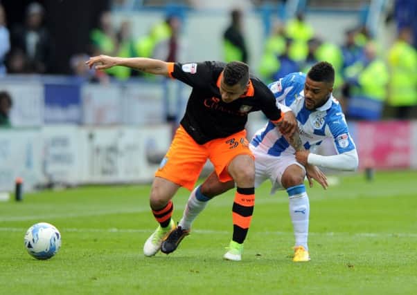 Huddersfield Town's Elias Kachunga grapples with Sheffield Wednesday's Daniel Pudil. Picture Tony Johnson.
