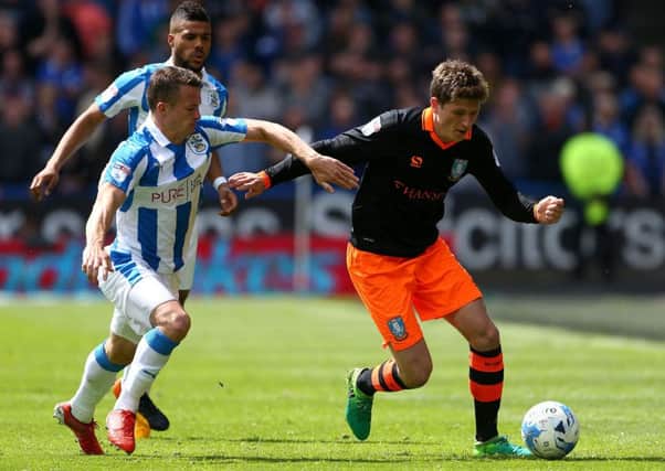 Huddersfield Town's Jonathan Hogg (left) and Sheffield Wednesday's Adam Reach battle for the ball. Picture: Dave Thompson/PA