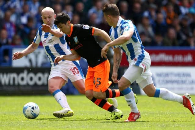 Huddersfield Town's Aaron Mooy and Jonathan Hogg battle for the ball with Sheffield Wednesday's Fernando Forestieri . Picture: Dave Thompson/PA