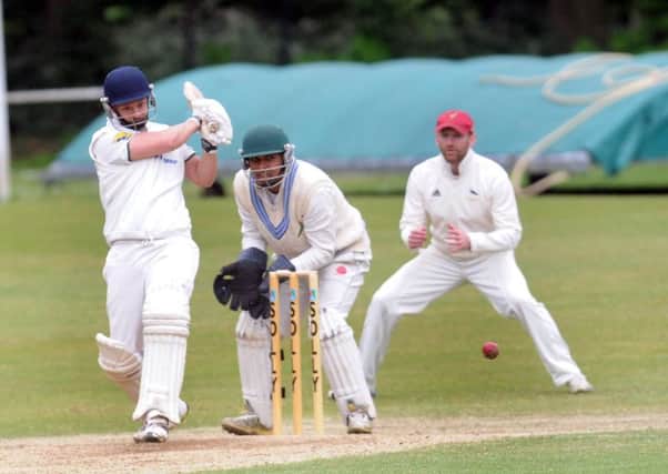 Dave Cummings of New Farnley sends the ball to the boundary