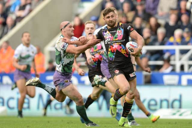 St Helens' Tommy Makinson beats the challenge of Hull FC's Danny Houghton (Photo: PA)