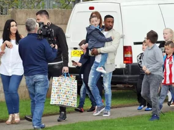 Bradley Lowery is carried by footballer Jermaine Defore during his sixth birthday party