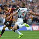 Millwall's Shaun Hutchinson swoops in on Bradford's  Billy Clarke as he lines up a shot at Wembley on Saturday.  Picture: Bruce Rollinson