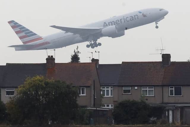 An airplane takes off over the rooftops of nearby houses at Heathrow Airport in Harmondsworth, London