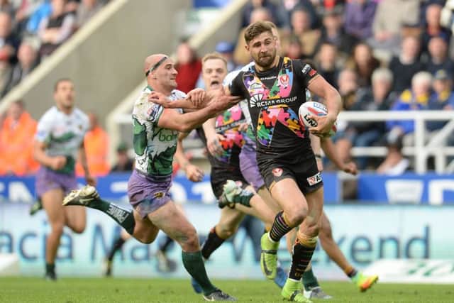 St Helens' Tommy Makinson beats the challenge of Hull FC's Danny Houghton at St James' Park. Picture: Anna Gowthorpe/PA.