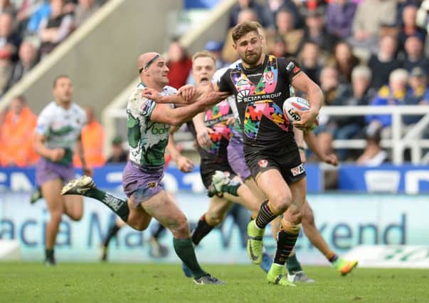 St Helens' Tommy Makinson beats the challenge of Hull FC's Danny Houghton. Picture: Anna Gowthorpe/PA
