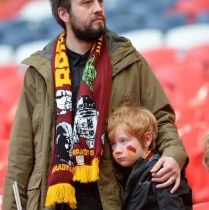 A young Bradford fan is consoled by his father at full time..  Picture: Bruce Rollinson